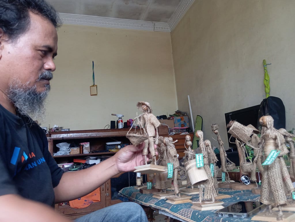 Deretan miniatur figur manusia di tempat workshop Goni Craft Natural Art, Kota Bandung, Sabtu (1/8/2026). Karya hasil kerajinan tangan Kosasih ini, berbahan dasar karung goni bekas dan bahan-bahan alami lainnya. Muhamad Nizar/tirto.id. Newsplus Cerita Perajin Berbahan Karung Goni
