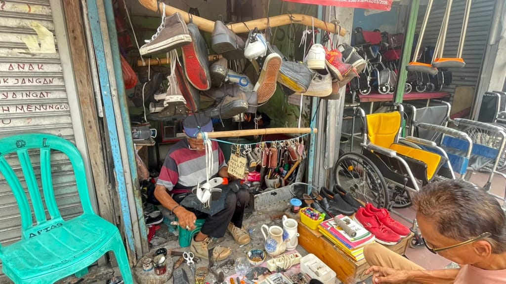 Yanto ketika sedengan memperbaiki flatshoes, di Ruko Jalan Dewi Sartika, Rabu (5/8/2026). FOTO/Putri Az zahra Menjahit Harapan di Tepi Jalan Dewi Sartika