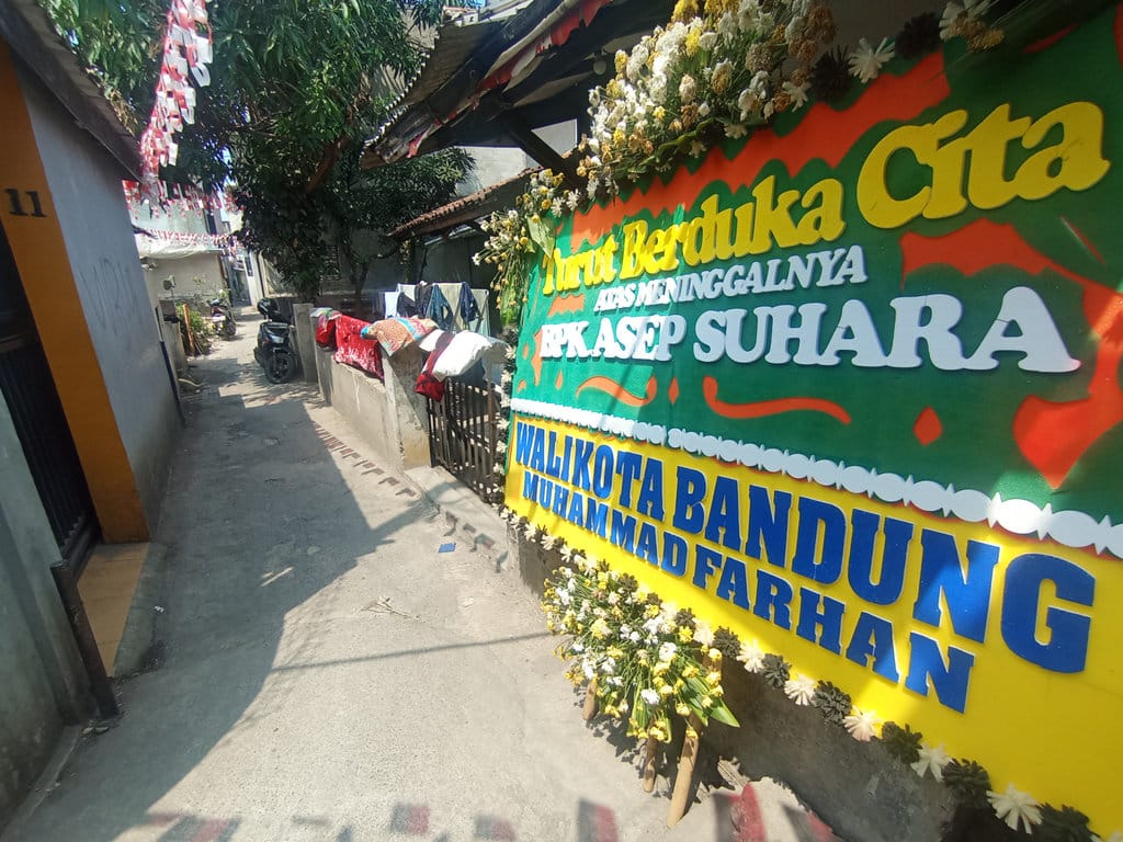 Sejumlah karangan bunga berduka cita terlihat di sekitar rumah duka Aiptu Asep Suhara di Jalan Gumuruh, Buahbatu, Kota Bandung, Rabu (12/8/2026). Muhamad Nizar/tirto.id. rumah duka Aiptu Asep Suhara