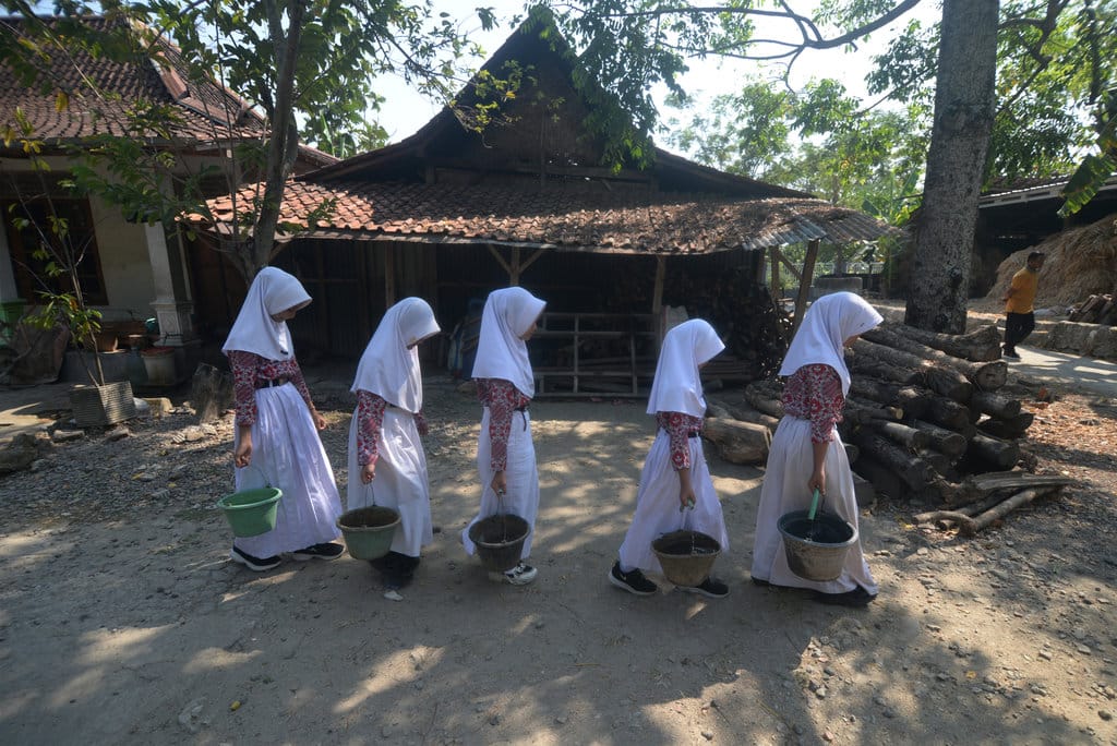 Sejumlah siswa Sekolah Dasar (SD) Negeri 1 Burikan membawa ember berisi air dari rumah menuju sekolah di Cawas, Klaten, Jawa Tengah, Kamis (13/8/2026). ANTARA FOTO/Aloysius Jarot Nugroho/kye Siswa membawa air untuk kebutuhan di sekolah