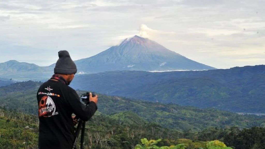 Arsip foto - Fotografer bersiap memotret Gunung Kerinci yang sedang mengembuskan gas dan material ke udara yang terlihat dari Desa Belui, Depati Tujuh, Kerinci, Jambi, Jumat (4/11/2022). ANTARA FOTO/Wahdi Septiawan/foc/aa. Gunung Kerinci