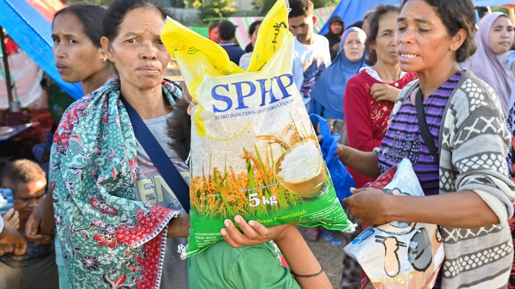 Pengungsi membawa beras SPHP di posko pengungsian korban gempa bumi NTT di Lapangan Barangkolong, Reo, NTT, Rabu (19/8/2026). Kementerian Pertanian menjamin ketersediaan stok beras bagi seluruh pengungsi terdampak gempa di NTT dengan perkiraan kebutuhan mencapai 300 ton per bulan. ANTARA FOTO/Fikri Yusuf/tom. Kementan jamin ketersediaan beras bagi pengungsi gempa NTT