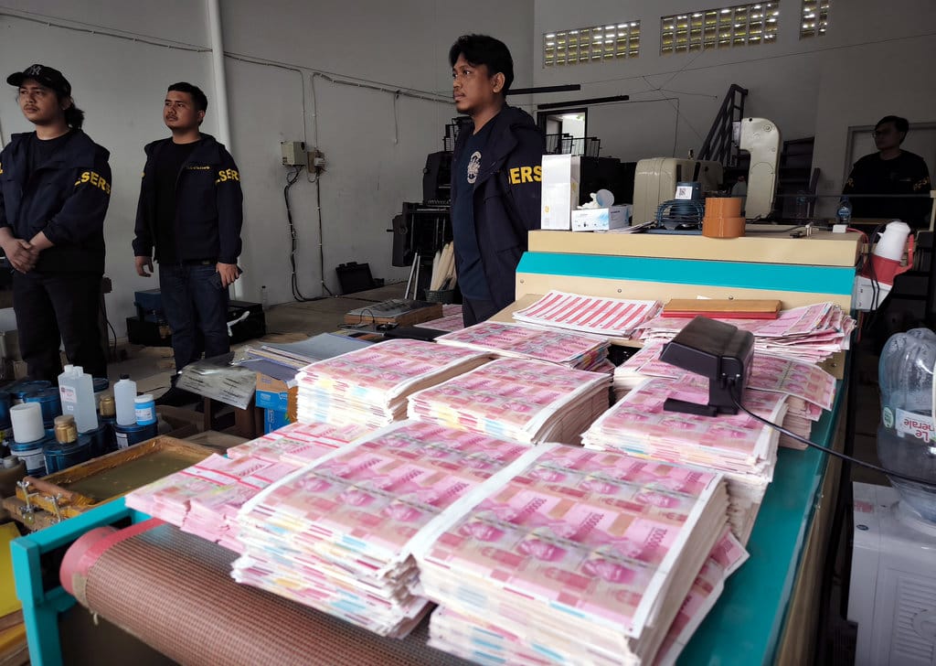 Petugas kepolisian berada di dekat tumpukan uang palsu saat melakukan penggerebekan di Taman Tekno Bumi Serpong Damai (BSD), Serpong, Tangerang Selatan, Banten, Sabtu (22/82026). Subdit Ekonomi dan Perbankan Ditreskrimsus Polda Metro Jaya berhasil melakukan penggerebekan dan pengungkapan terkait percetakan uang palsu serta penemuan sebanyak 360.000 lembar uang pecahan Rp100 ribu setara Rp36 miliar yang semuanya palsu. ANTARA FOTO/Mayra Izzah/YU Penggerebekan percetakan uang palsu di Tangerang