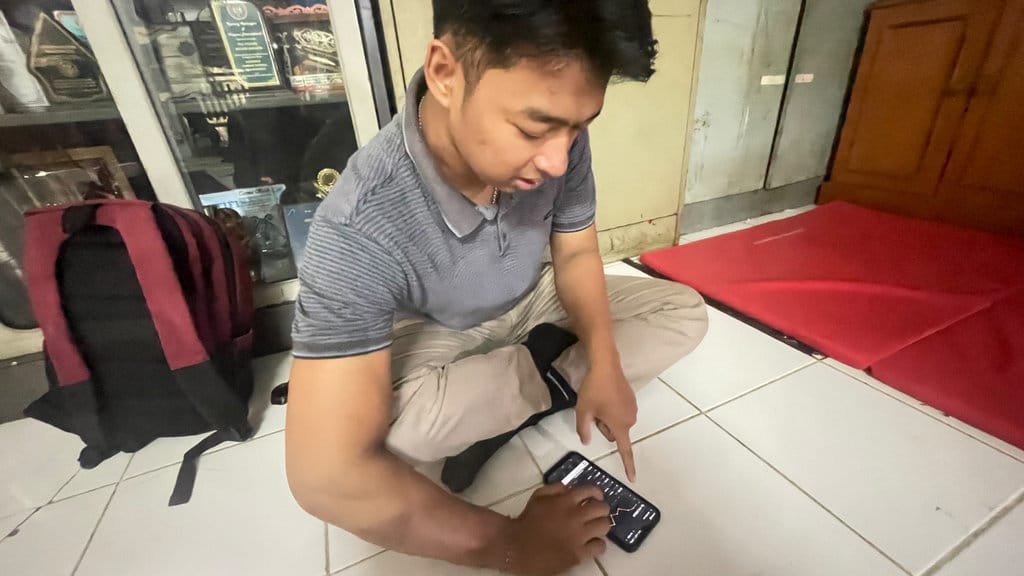 Luthfan tengah melihat catatan pengeluaran dan pemasukan uang setiap bulannya, saat diwawancarai di PNJ, Rabu (26/08/2026). (FOTO/Putri Az zahra) Siasat Bertahan Mahasiswa Rantau