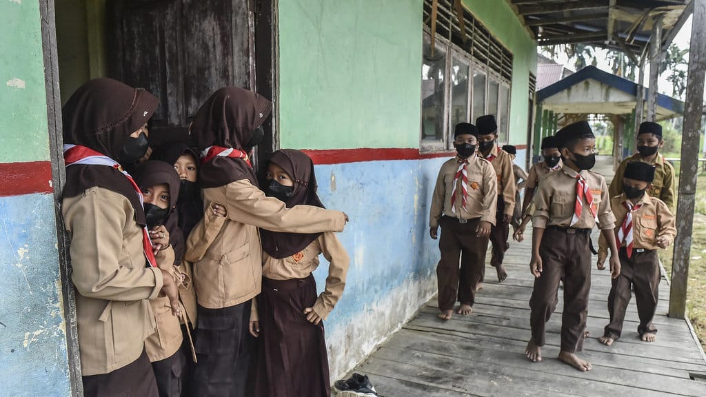 Siswa kelas 3 dan 4 SDN 197 Desa Rawasari bermain di luar kelas dengan memakai masker saat istirahat belajar mengajar di Tanjung Jabung Timur, Jambi, Rabu (26/8/2026). Pihak sekolah mewajibkan para siswanya memakai masker yang dibagikan secara gratis guna mengurangi dampak asap kebakaran hutan dan lahan (karhutla) yang terjadi sejak Selasa (25/8) di desa itu. ANTARA FOTO/Wahdi Septiawan/nz. Pelajar terdampak karhutla mulai pakai masker