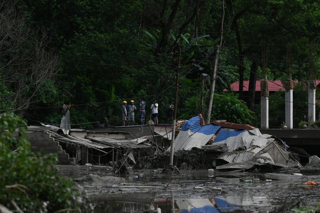 Tim penyelamat mencari korban selamat di tengah lumpur dan reruntuhan bangunan pascabanjir bandang dan tanah longsor di Devghat, Distrik Nuwakot, Nepal, pada 26 Agustus 2026. Bencana banjir besar dan tanah longsor di perbatasan Nepal-Tibet menewaskan sedikitnya 103 orang pada 26 Agustus 2026 dan menyebabkan ratusan orang lainnya hilang, banyak di antaranya merupakan wisatawan asing. Petugas bantuan menyatakan bahwa seluruh permukiman telah 'rata dengan tanah'. Menurut kementerian pariwisata, sekitar 403 wisatawan—341 di antaranya warga asing—sempat tidak diketahui keberadaannya selama beberapa jam setelah bencana terjadi. AFP/ PRAKASH MATHEMA Banjir Bandang Nepal