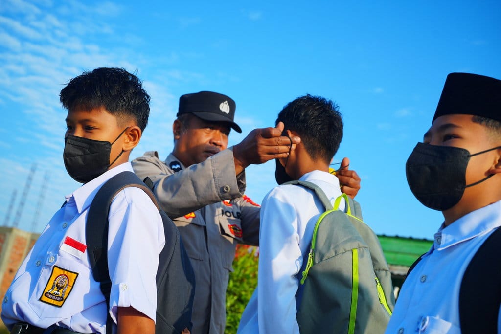 Personel Polsek Lalolae memasangkan masker kepada siswa MTs Al Bukhari yang terdampak asap Karhutla di Kecamatan Lalolae, Kolaka Timur, Sulawesi Tenggara, Senin (31/8/2029). Pembagian masker tersebut guna melindungi siswa dari dampak lahan gambut yang terbakar dan menimbukan asap tebal. ANTARA FOTO/Jojon/agr Pembagian masker untuk siswa terdampak asap karhutka