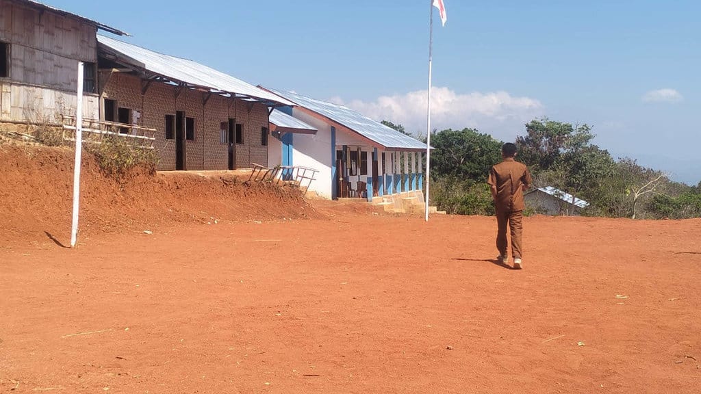 Seorang guru berjalan di halaman sekolahnya pada hari pertama aktivitas kegiatan belajar mengajar di masa tanggap darurat Gempa NTT. Tirto/Fransiskus Adryanto Pratama SMKS Karya Murni
