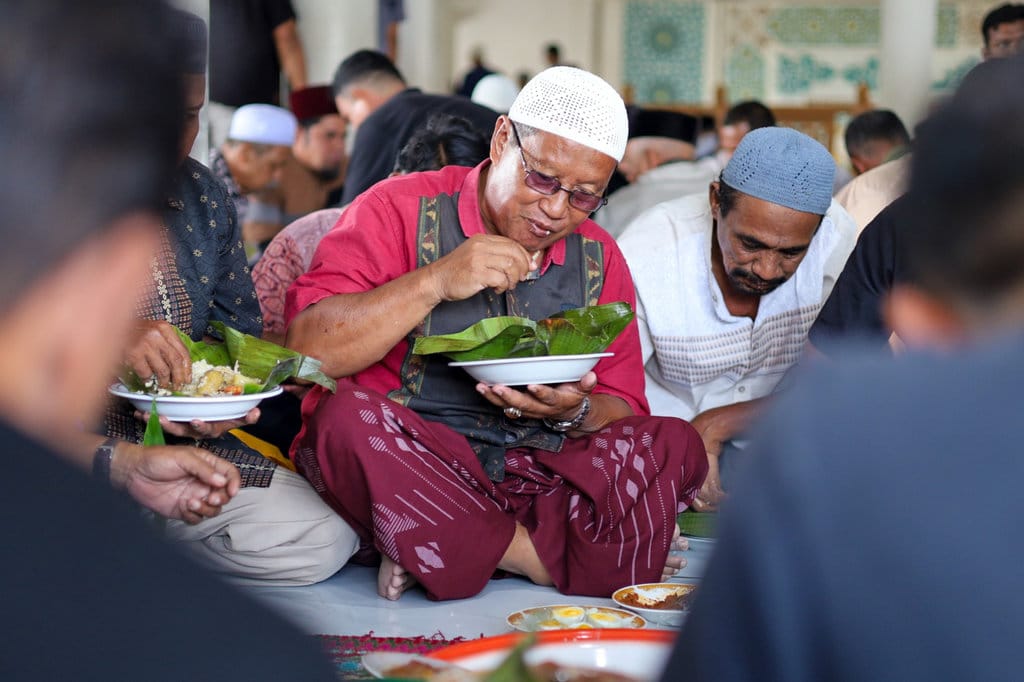 Masyarakat menikmati hidangan maulid Nabi Muhammad di Meunasah (surau) di kabupaten Aceh Besar. (Foto : tirto.id/Firhan Farabi) Newsplus Merawat Tradisi dari Sebungkus Nasi