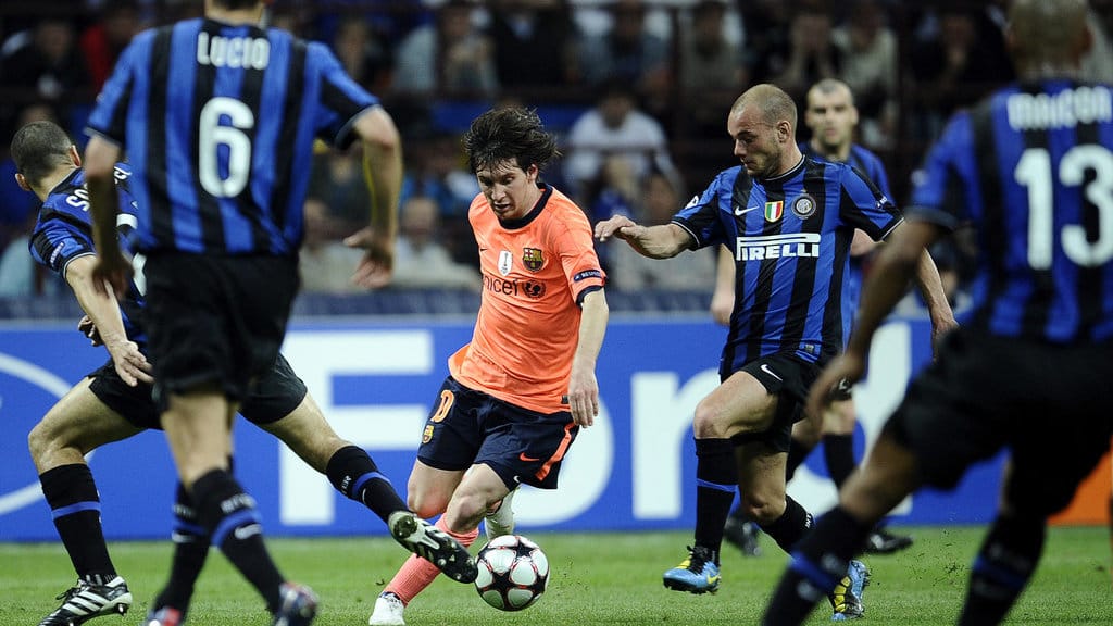 Penyerang Barcelona asal Argentina, Lionel Messi (tengah), berebut bola dengan gelandang Inter Milan asal Belanda, Wesley Sneijder (kedua dari kanan), dalam pertandingan sepak bola leg pertama semifinal Liga Champions UEFA antara Inter Milan dan Barcelona pada 20 April 2010 di Stadion San Siro, Milan. (Photo by FILIPPO MONTEFORTE / AFP) Inter Milan vs Barcelona 2010