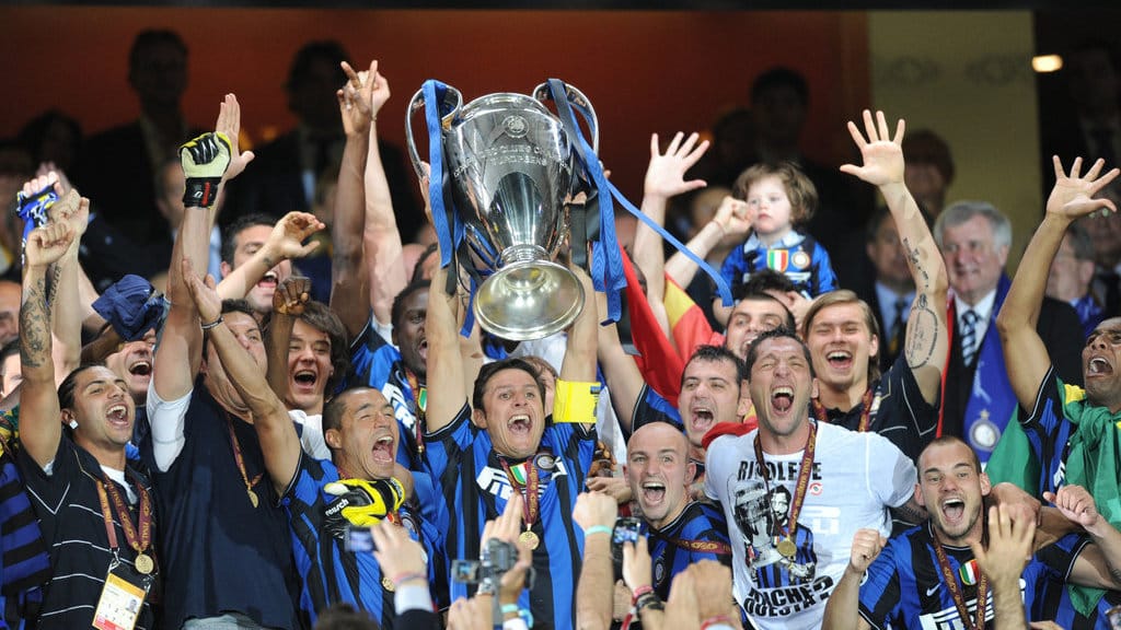 Para pemain Inter Milan merayakan kemenangan bersama trofi setelah memenangkan pertandingan final Liga Champions UEFA melawan Bayern Munich di Stadion Santiago Bernabeu, Madrid, pada 22 Mei 2010. Inter Milan menjuarai Liga Champions berkat kemenangan 2-0 atas Bayern Munich dalam laga final di Santiago Bernabeu tersebut. Penyerang asal Argentina, Diego Milito, mencetak kedua gol bagi tim asuhan Jose Mourinho yang berhasil meraih *treble* (tiga gelar juara) pada musim itu. (Photo by CHRISTOPHE SIMON / AFP) Inter Milan Juara Liga Champions 2010