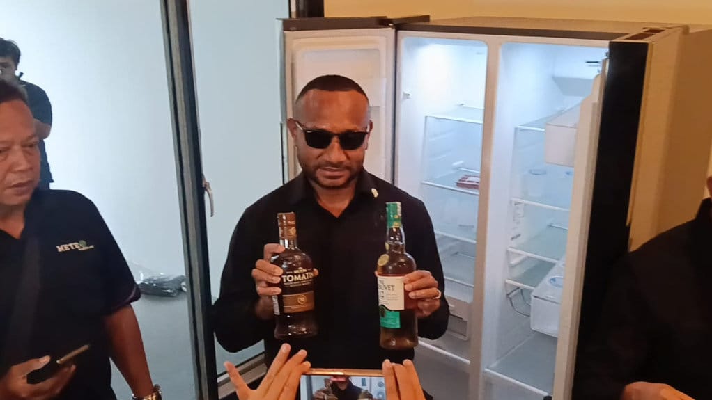 Anggota Komisi XIII DPR RI fraksi Gerindra, Yan Permenas Mandenas, saat menunjukkan minuman beralkohol yang ditemukan dalam kulkas 'klaster mewah' Lapas Kelas IIA Cibinong, Bogor, Rabu (30/9/2026). tirto.id/Aulia Umayna Komisi XIII DPR Sidak Lapas Kelas IIA Cibinong