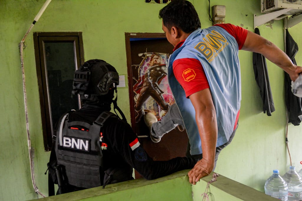 Petugas BNN mendobrak pintu salah satu rumah saat penggerebekan narkoba di Kampung Ambon, Jakarta, Kamis (15/10/2026). Sebanyak 210 petugas gabungan dari Direktorat Tindak Pidana Narkoba Bareskrim Polri, Badan Narkotika Nasional (BNN), dan Polda Metro Jaya melakukan penggerebekan lokasi yang diduga sebagai sarang narkoba di Kompleks Permata, Kedaung Kaliangke, Cengkareng, Jakarta Barat, atau dikenal sebagai Kampung Ambon. ANTARA FOTO/Fathul Habib Sholeh/sgd/nym. Penggerebekan narkoba di Kampung Ambon