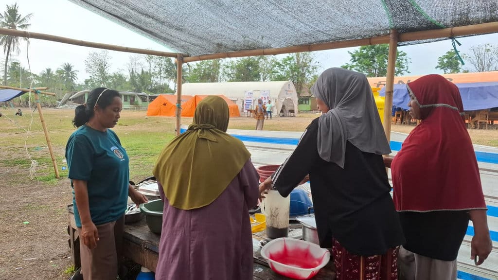 Hamidah bergotong royong bersama ibu-ibu dalam memasak untuk kebutuhan anak-anak mereka dan kelurga. (FOTO/Jay Jasmin) Ibu Hamidah Bertahan di Tenda Darurat