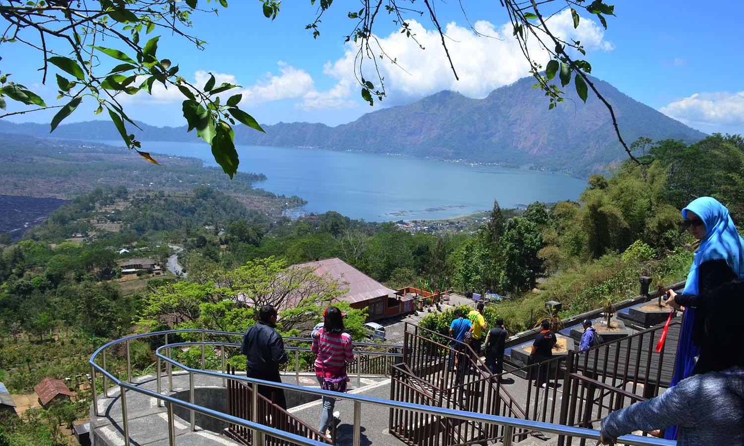 Wisatawan menikmati pemandangan gunung dan danau di kawasan wisata Geopark Gunung Batur, Kintamani, Bangli, Bali, Minggu (13/9). Kawasan geopark Gunung Batur yang telah ditetapkan UNESCO sebagai bagian jaringan geopark dunia tersebut menjadi salah satu objek wisata alam sekaligus edukasi yang diminati wisatawan domestik dan mancanegara di Bali. ANTARA FOTO/Fikri Yusuf/foc/15.