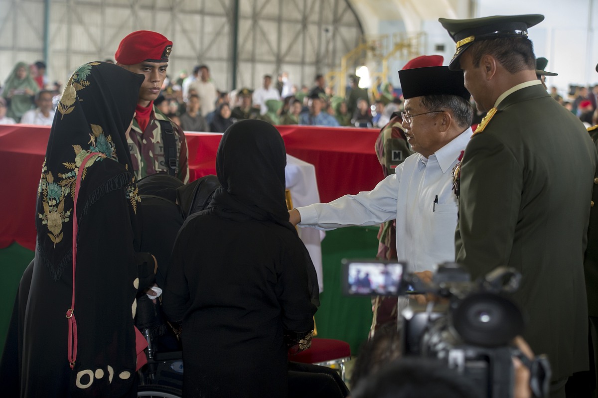Wapres Jusuf Kalla (kedua kanan) didampingi Pangdam Jaya Mayjen TNI Teddy Lhaksmana (kanan) menyampaikan ucapan belasungkawa kepada keluarga korban jatuhnya Helikopter TNI AD jenis Bell 412 EP ketika acara persemayaman di Hanggar Skadron Udara 17 Lanud Halim Perdanakusuma, Jakarta, Selasa (22/3). Helikopter TNI AD jenis Bell 412 EP dengan nomor HA 5171 pada Hari Minggu (20/3) sekitar pukul 17.55 WITA jatuh di atas perkebunan Kelurahan Kasiguncu, Kecamatan Poso Pesisir, Sulawesi Tengah menewaskan 13 prajurit TNI. ANTARA FOTO/Widodo S. Jusuf/foc/16.