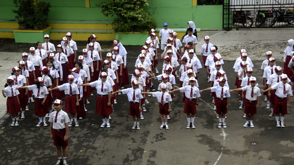 Para siswa melaksanakan upacara bendera saat hari pertama masuk sekolah di SDN Duren Tiga 1, Jakarta, Senin (10/7). tirto.id/ANdrey Gromico Hari Pertama siswa masuk sekolah