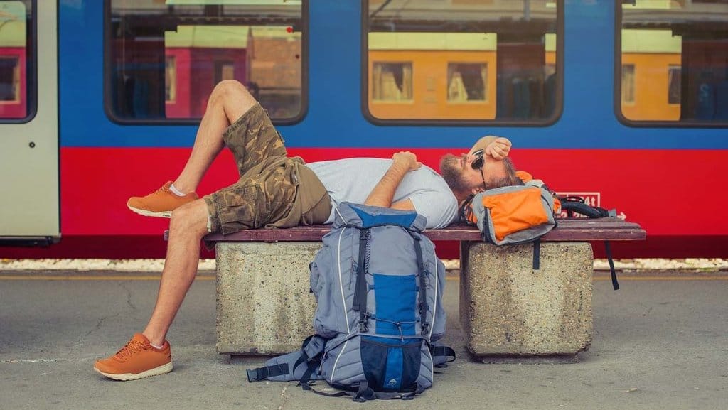 Seorang backpacker tidur di stasiun kereta api. FOTO/iStock ilustrasi Backpacker