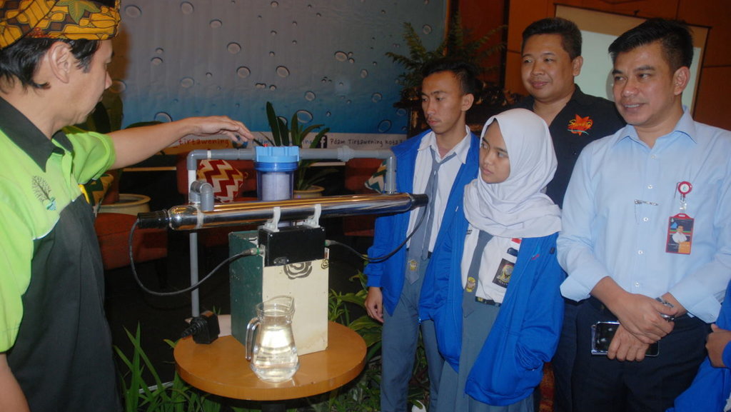 Pelajar didampingi Dirut PDAM Tirtawening Kota Bandung Sonny Salimi menyimak penjelasan proses pengolahan air hujan menjadi air minum, saat Sosialisasi Peran Serta PDAM Dalam Penyediaan Air Minum Untuk Masyarakat, di Bandung, Senin (4/12/2017). ANTARA FOTO/Fahrul Jayadiputra MESIN PENGOLAH AIR HUJAN