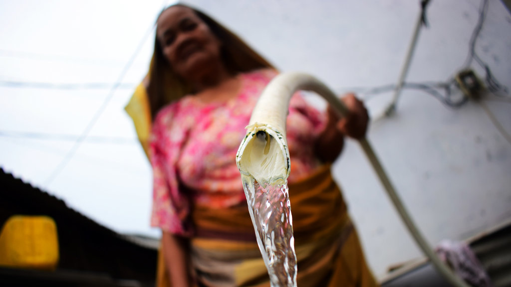 Warga Kamal Muara mengalirkan air sumur bor pada bak. tirto.id/Arimacs Wilander KAMPUNG AIR TADAH HUJAN