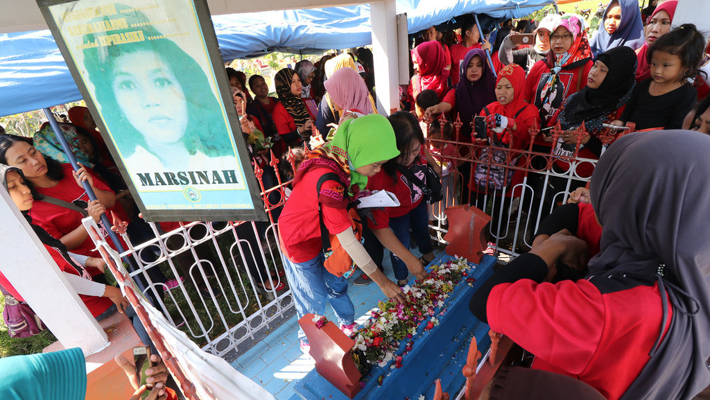 Sejumlah buruh menabur bunga di atas makam Marsinah di Desa Nglundo, Nganjuk, Jawa Timur, Selasa (1/5). Ribuan buruh dari sejumlah daerah melakukan ziarah di makam pejuang buruh Marsinah guna memperingati Hari Buruh Internasional. ANTARA FOTO/Prasetia Fauzani/aww/18. BURUH ZIARAH MAKAM MARSINAH