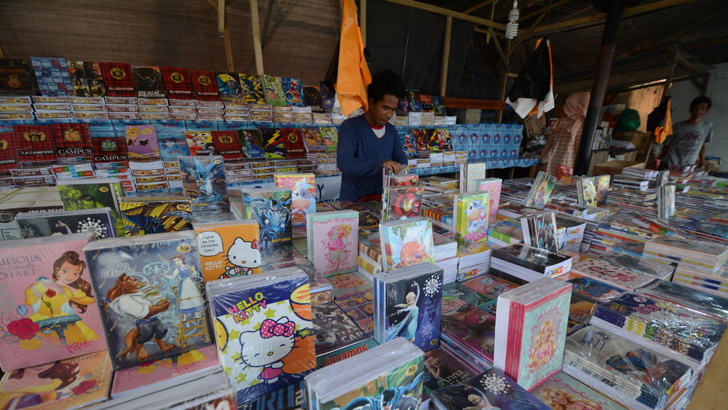 Pedagang menata buku tulis yang dijualnya di salah satu ruas jalan di Palu, Sulawesi Tengah, Jumat (6/7/2018). ANTARAFOTO/Basri Marzuki PERMINTAAN BUKU TULIS