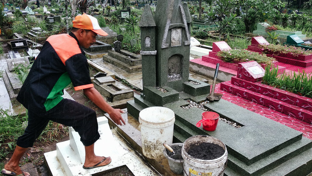 Seorang petugas kebersihan makam Tempat Pemakaman Umum (TPU) Giriloyo Kota Magelang menunjukkan makam yang rusak pada, Kamis (3/1/2019). tirto.id/Irwan A. Syambudi Perusakan Makam