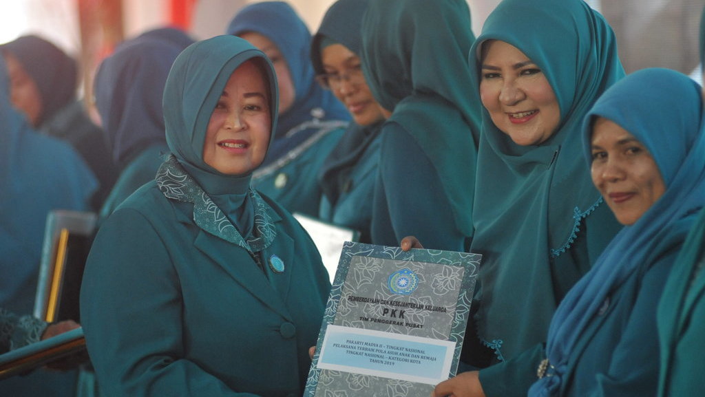 Ketua Umum TP-PKK Erni Guntarti Tjahjo Kumolo menyerahkan penghargaan kepada Ketua TP-PKK Sumbar Nevi Zuairina pada pembukaan Hari Kesatuan Gerak Pemberdayaan Kesejahteraan Keluarga (HKG-PKK) Nasional 2019 ke-47 di Lapangan Imam Bonjol, Padang, Sumatera Barat, Rabu (24/7/2019). ANTARA FOTO/Iggoy el Fitra/wsj. HARI KESATUAN GERAK PKK NASIONAL 2019