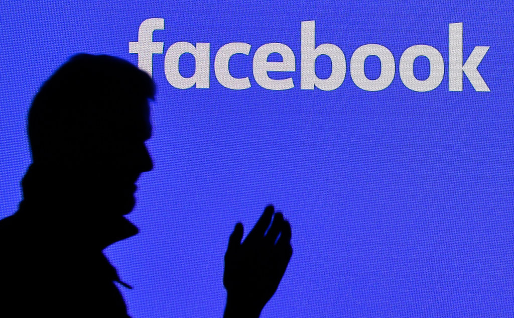 Seorang pria melewati layar facebook di Gamescom di Cologne, Jerman, Selasa, 20 Agustus 2019. AP Photo/Martin Meissner Ilustrasi moderator facebook