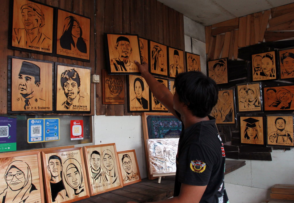 Perajin merapikan sketsa kayu wajah pesanan pelanggan di Cinere, Depok, Jawa Barat. ANTARA FOTO/Muhammad Iqbal/aww. PERAJIN SKETSA WAJAH BERMATERI KAYU