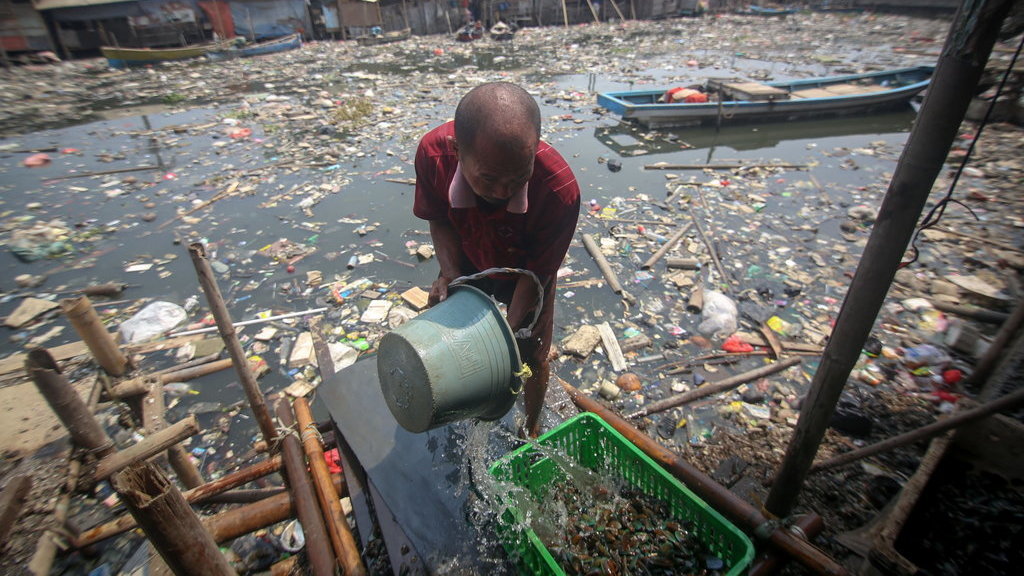 Seorang warga mengambil air untuk membersihkan kerang dagangannya di Kali Apuran yang tercemar limbah di Dadap, Kabupaten Tangerang, Banten, Rabu (20/11/2019). ANTARA FOTO/Fauzan/pras. KALI APURAN TERCEMAR LIMBAH