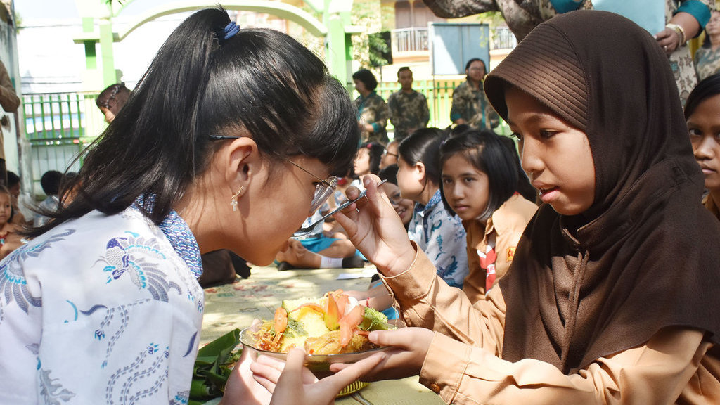Murid SDN 01 Nambangan Lor makan pagi bersama dengan murid SDK Santa Maria di Kota Madiun, Jawa Timur, Jumat (20/12/2019). ANTARA FOTO/Siswowidodo/foc. MAKAN BERSAMA TUMPENG NATAL
