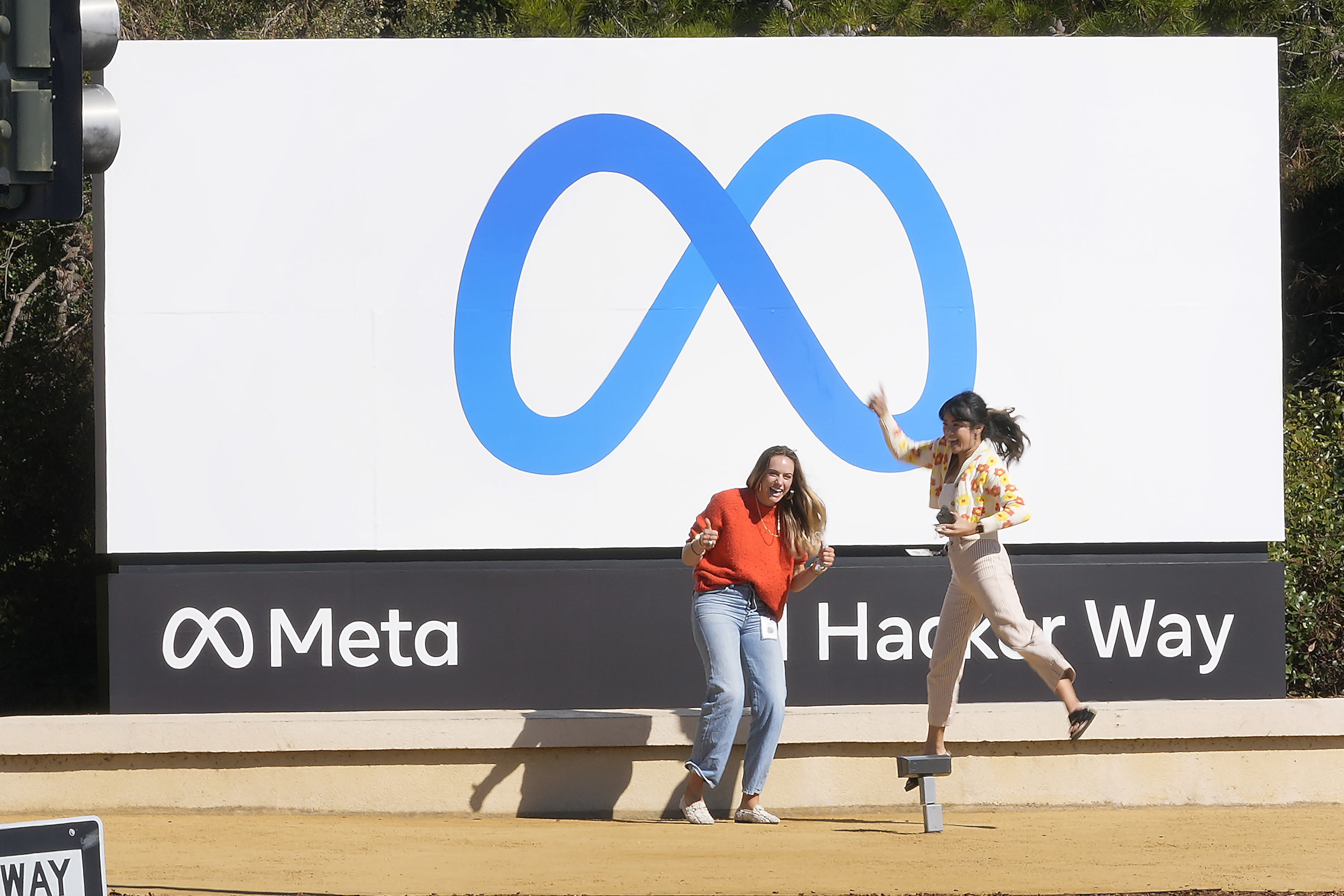 Karyawan Facebook berfoto dengan nama dan logo baru perusahaan di luar kantor pusatnya di Menlo Park, California, Kamis, 28 Oktober 2021, setelah perusahaan mengumumkan perubahan nama menjadi Meta Platforms Inc. (AP Photo/Tony Avelar) Facebook Meta