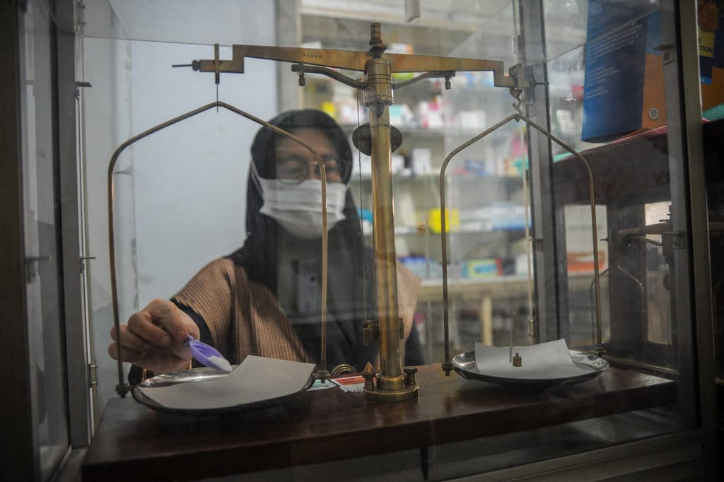 Apoteker meracik obat di sebuah apotek di Kota Bandung, Jawa Barat, Rabu (19/10/2022). ANTARA FOTO/Raisan Al Farisi/YU PENGHENTIAN SEMENTARA OBAT BEBAS BENTUK SIROP
