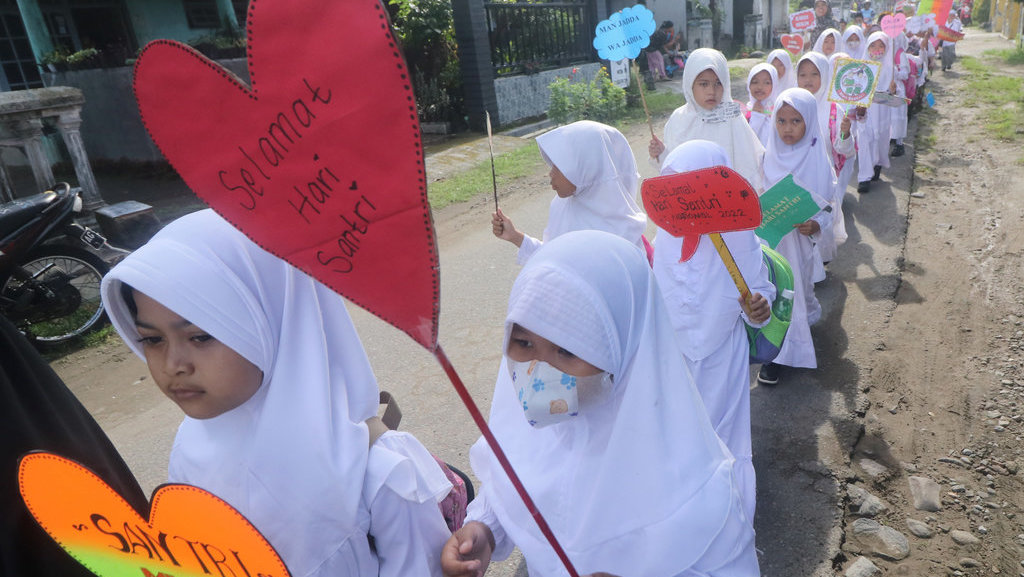 Sejumlah pelajar membawa poster saat mengikuti pawai Hari Santri Nasional di Desa Tugurejo Kediri, Jawa Timur, Sabtu (22/10/2022). Pawai tersebut diikuti pelajar dari sejumlah sekolah tingkat TK hingga SD. ANTARA FOTO/Prasetia Fauzani/nym. PAWAI HARI SANTRI NASIONAL
