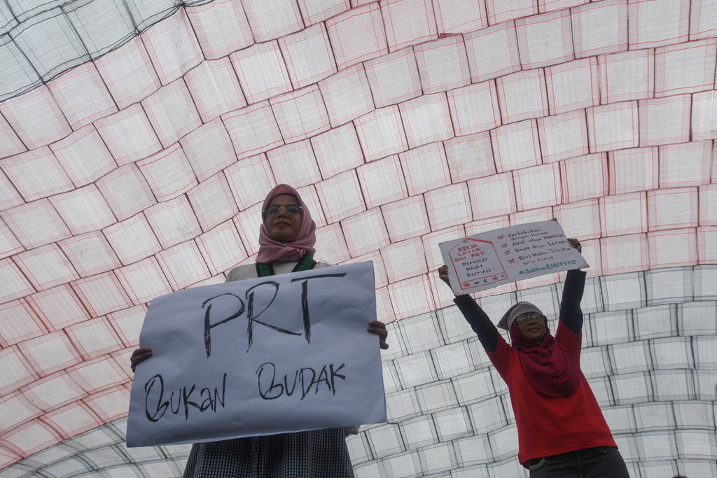 Sejumlah aktivis membawa poster di bawah kain lap raksasa yang dibentangkan dalam aksi damai memperingati Hari Pekerja Rumah Tangga di depan kompleks Parlemen, Senayan, Jakarta, Rabu (15/2/2023). ANTARA FOTO/Aditya Pradana Putra/hp. AKSI TUNTUT DPR SAHKAN RUU PPRT