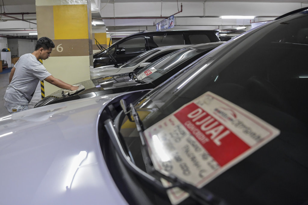 Pedagang mobil bekas membersihkan mobil yang dijual di Gedung Parkir Blok M Square, Jakarta, Jumat (14/4/2023). Menurut pedagang, menjelang mudik Lebaran 2023 penjualan mobil bekas tipe low multi purpose vehicle (LMPV) meningkat untuk keperluan mudik. ANTARA FOTO/Galih Pradipta/rwa. PENJUALAN MOBIL BEKAS