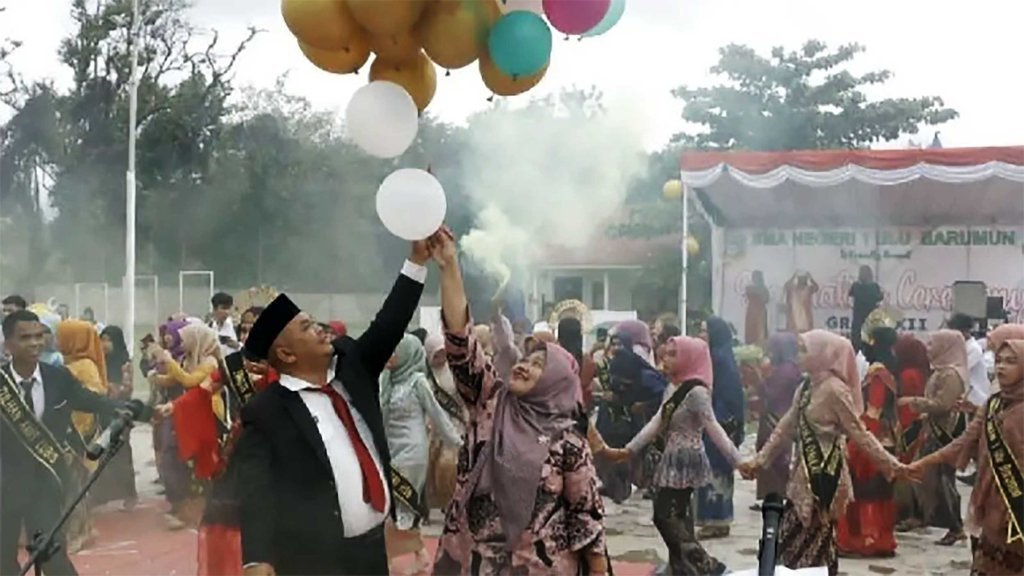 Kepala SMA N 1 Ulu Barumun Bidarlis Nur Ibrahim Rangkuti bersama istri melepas balon rangkaian acara perpisahan siswa siswi kelas XII, di Halaman sekolah setempat, Kamis (16/3) semalam. FOTO/ANTARA Perpisahan Sekolah SMA