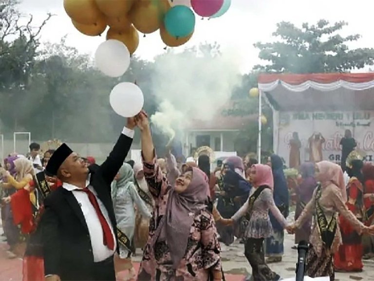 Kepala SMA N 1 Ulu Barumun Bidarlis Nur Ibrahim Rangkuti bersama istri melepas balon rangkaian acara perpisahan siswa siswi kelas XII, di Halaman sekolah setempat, Kamis (16/3) semalam. FOTO/ANTARA Perpisahan Sekolah SMA