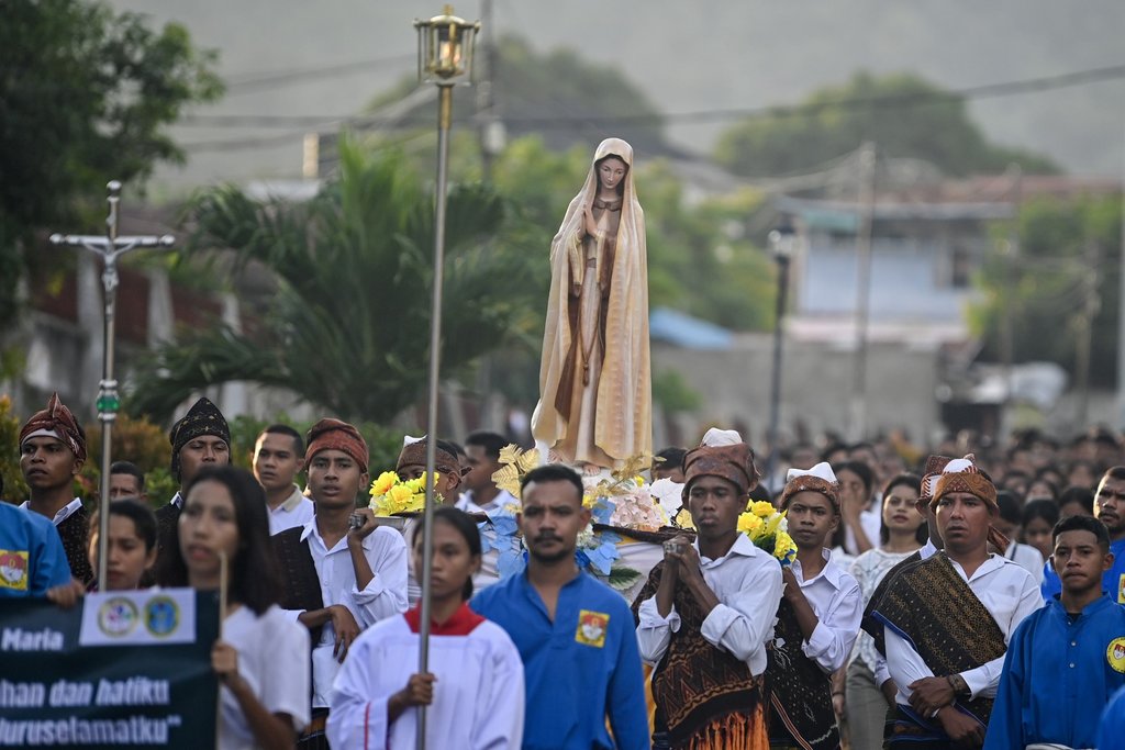 Umat Katolik berjalan saat mengikuti arak-arakan patung Bunda Maria dalam penutupan bulan Maria yang melintas di kawasan El Tari, Kabupaten Ende, NTT, Kamis (30/5/2024). Kegiatan tersebut sebagai bentuk penghormatan menandai berakhirnya devosi umat Katolik kepada Bunda Maria pada bulan Mei. ANTARA FOTO/M Risyal Hidayat/nym. Penutupan bulan Maria di Ende