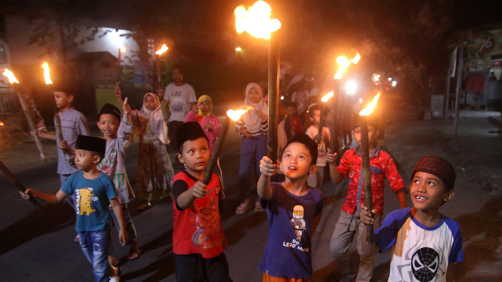 Sejumlah anak membawa obor saat takbir keliling di Kelurahan Ngletih, Kota Kediri, Jawa Timur, Minggu (16/6/2024). ANTARA FOTO/Prasetia Fauzani/tom. Takbir keliling sambut Idul Adha