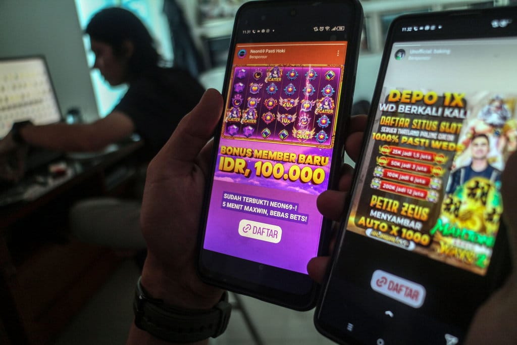 Warga melihat iklan judi online melalui gawainya di Bogor, Jawa Barat, Rabu (26/6/2024). ANTARA FOTO/Yulius Satria Wijaya/foc. Provinsi dengan pelaku judi online terbanyak nasional