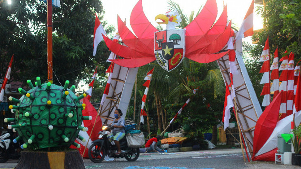 Warga melintas di gapura yang di hiasi pernak-pernik kemerdekaan di Komplek Kenanga Citra Puri Rt 07, Banjarmasin, Kalimantan Selatan, Senin (17/8/). ANTARA FOTO/Bayu Pratama S. gapura 17 agustus