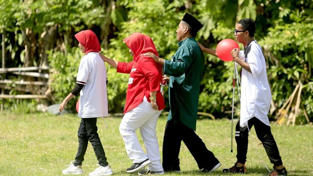 Sejumlah penyandang disabilitas saling menuntun usai mengikuti lomba membawa balon di Tenggela, Kabupaten Gorontalo, Gorontalo, Sabtu (17/8/2024).ANTARA FOTO/Adiwinata Solihin/rwa. Lomba HUT RI bagi lansia dan penyandang disabilitas
