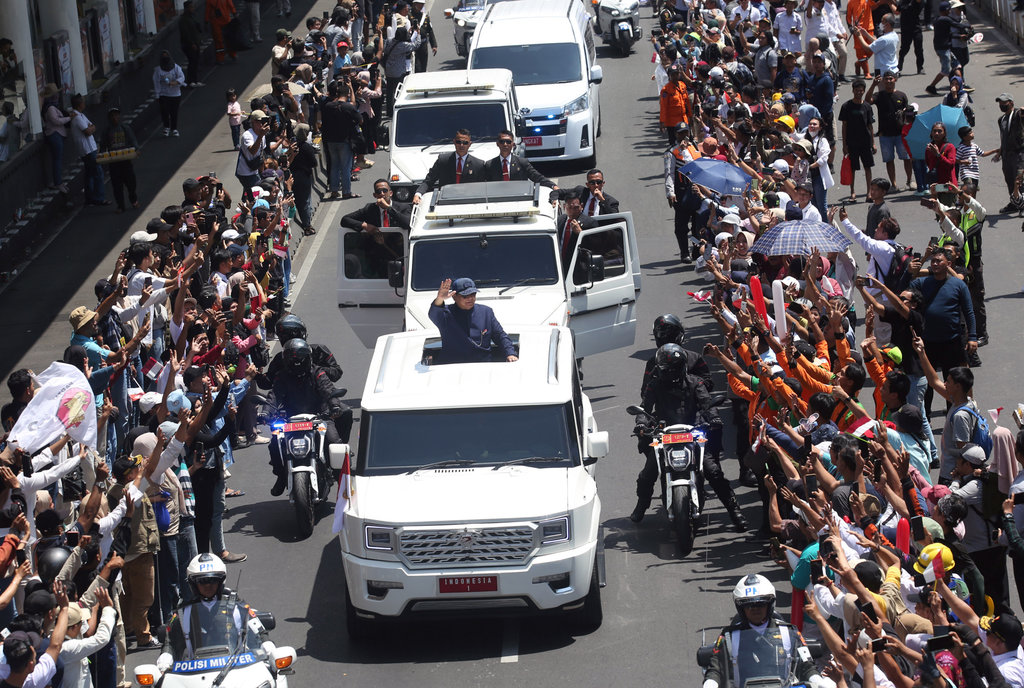 Presiden Prabowo Subianto melambaikan tangan ke warga saat melintasi kawasan Patung Sudirman di Jakarta, Minggu (20/10/2024). ANTARA FOTO/Muhammad Iqbal/YU Ribuan warga sambut Presiden dan Wakil Presiden baru