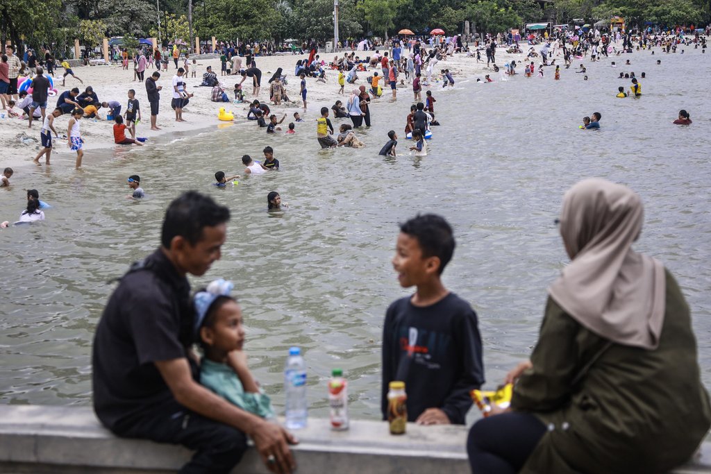 Pengunjung berwisata di Pantai Ancol Taman Impian, Jakarta. Pengelola Ancol Taman Impian mencatat hingga pukul 13.00 WIB, jumlah pengunjung mencapai 23.600 orang pada libur Natal 2024. ANTARA FOTO/Dhemas Reviyanto/Spt Libur Natal di Pantai Ancol