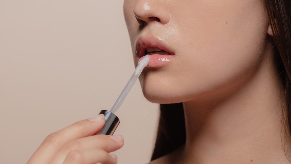 Ilustrasi perempuan menggunakan lip serum. FOTO/iStockphoto Ilustrasi lip gloss