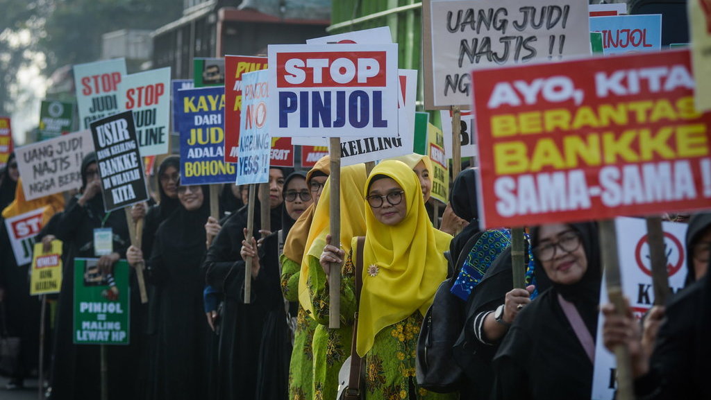 Sejumlah massa aksi menunjukkan poster saat unjuk rasa di Taman Elektrik, Kota Tangerang, Banten, Kamis (27/2/2025). ANTARA FOTO/Putra M. Akbar/foc. Aksi tolak judol dan pinjol di Tangerang