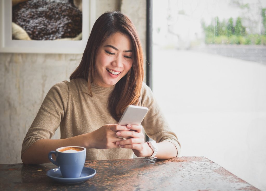 Wanita menggunakan ponsel. FOTO/iStockphoto Wanita menggunakan ponsel