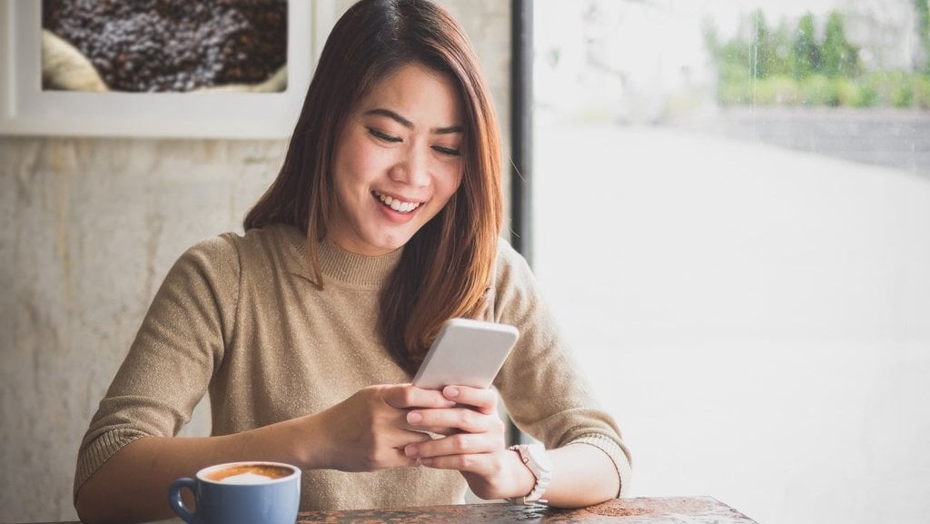 Wanita menggunakan ponsel